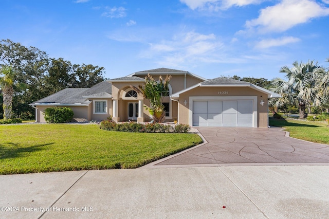 view of front of house with a garage and a front lawn