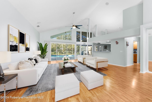 living room featuring ceiling fan, light hardwood / wood-style floors, and high vaulted ceiling