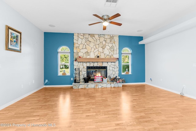 living room with ceiling fan, a healthy amount of sunlight, a fireplace, and light hardwood / wood-style flooring