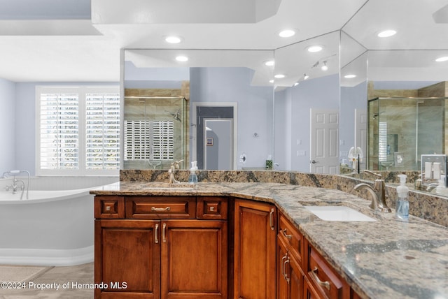 bathroom with tile patterned floors, vanity, and shower with separate bathtub