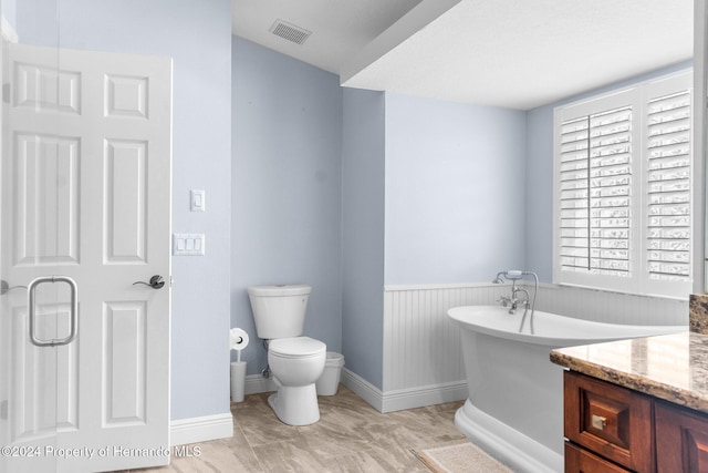 bathroom featuring vanity, toilet, and a bathing tub