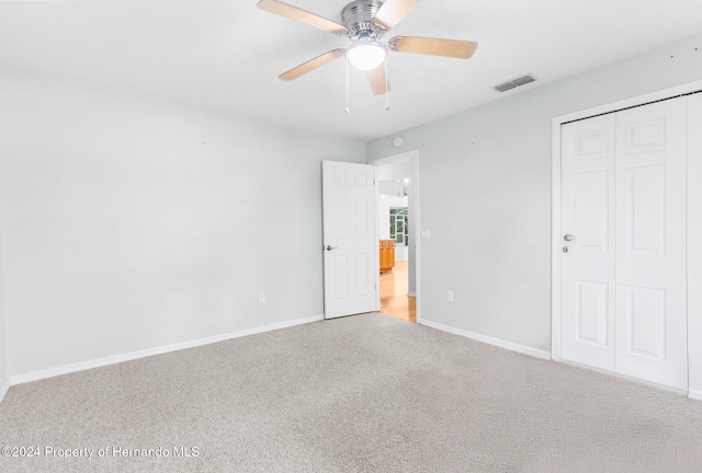 unfurnished bedroom featuring ceiling fan, a closet, and carpet floors