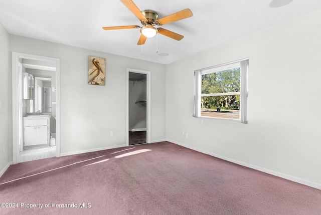 unfurnished bedroom featuring connected bathroom, ceiling fan, a spacious closet, carpet floors, and a closet