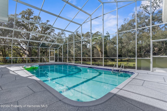 view of swimming pool featuring a lanai and a patio area