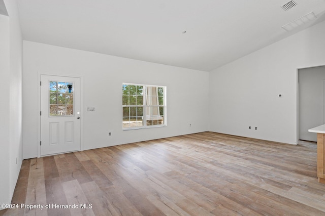 unfurnished living room with light wood-type flooring and vaulted ceiling