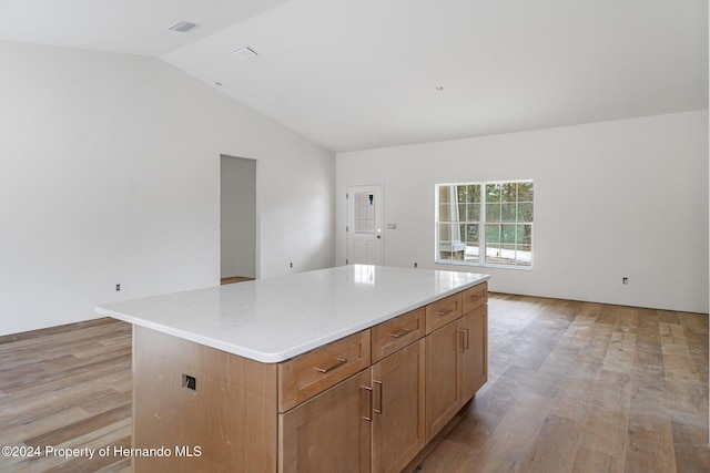 kitchen featuring a center island, lofted ceiling, and light hardwood / wood-style flooring