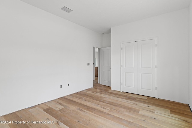 unfurnished bedroom with light hardwood / wood-style floors and a closet