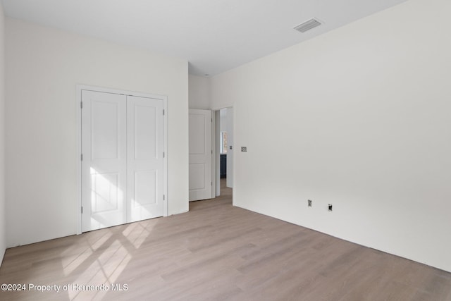 unfurnished bedroom featuring a closet and light wood-type flooring