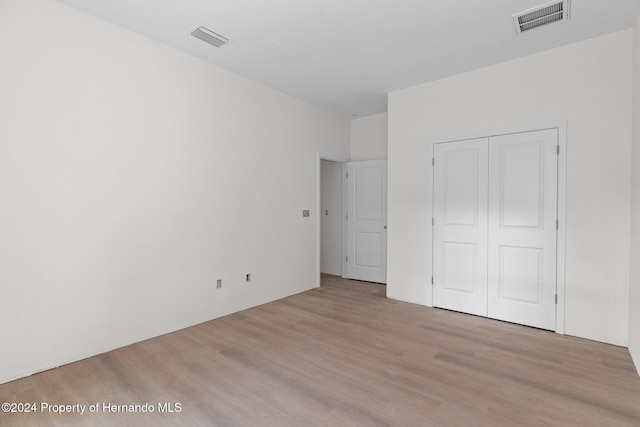 unfurnished bedroom with a closet and light hardwood / wood-style flooring