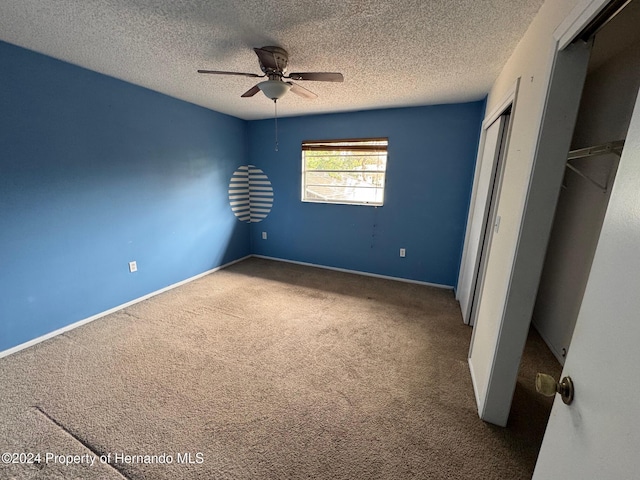 unfurnished bedroom with carpet flooring, ceiling fan, and a textured ceiling