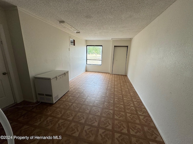 unfurnished room featuring a textured ceiling and parquet flooring