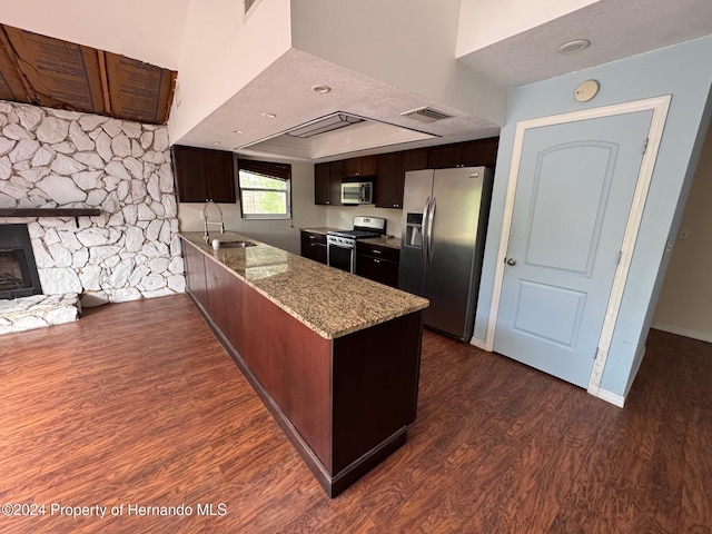 kitchen with light stone countertops, dark hardwood / wood-style flooring, stainless steel appliances, and sink