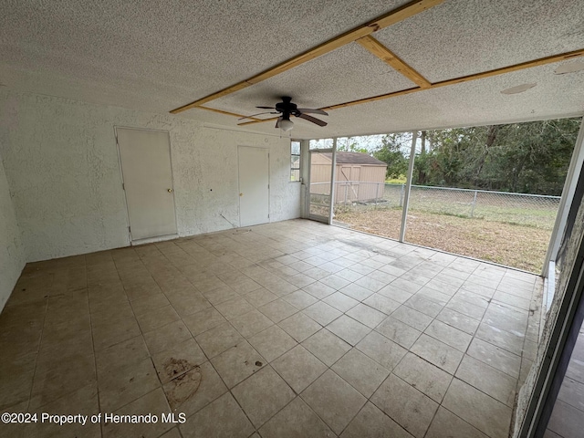 unfurnished sunroom with ceiling fan