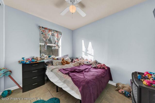 bedroom with tile patterned floors and ceiling fan