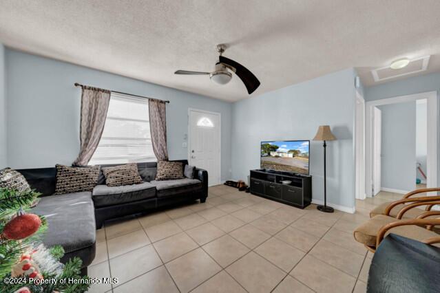 living room with ceiling fan and light tile patterned floors