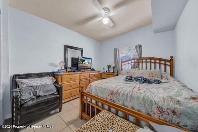 bedroom with light tile patterned floors and ceiling fan