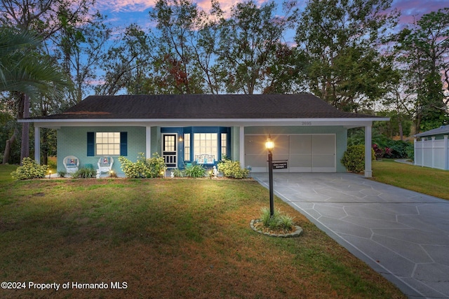 single story home with a garage and a yard