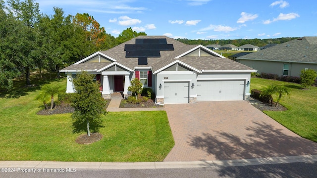 view of front of house featuring solar panels, a garage, and a front lawn