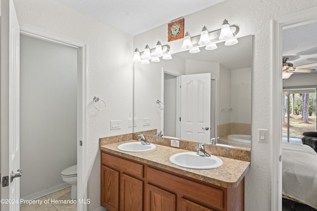 bathroom featuring ceiling fan, a bath, tile patterned floors, toilet, and vanity