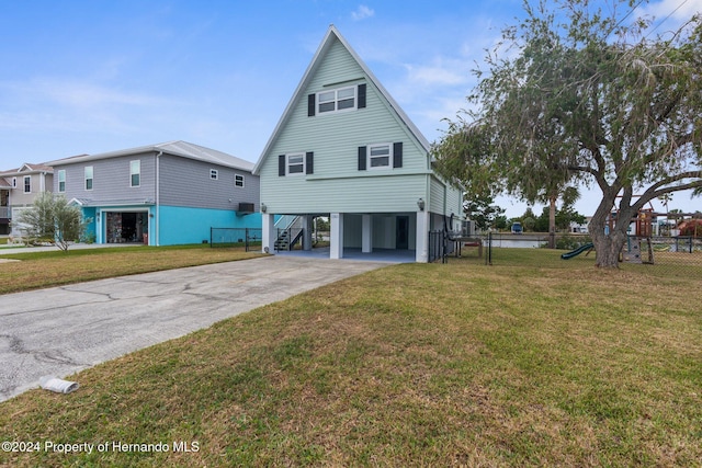 rear view of property with a lawn and a carport