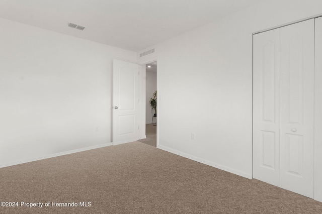 unfurnished bedroom with carpet floors and a closet