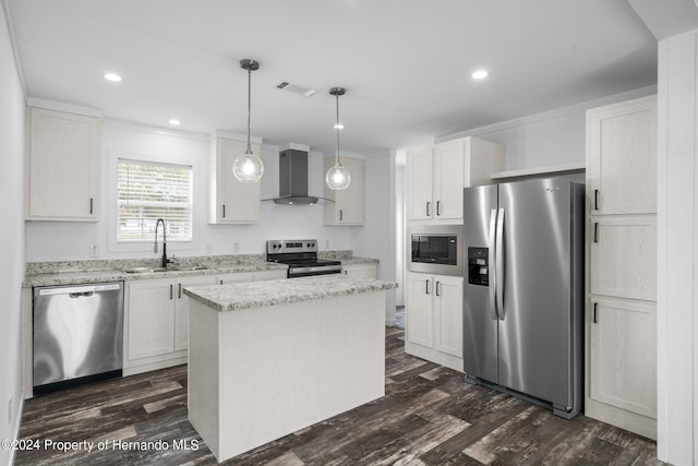 kitchen featuring sink, wall chimney exhaust hood, hanging light fixtures, stainless steel appliances, and a kitchen island