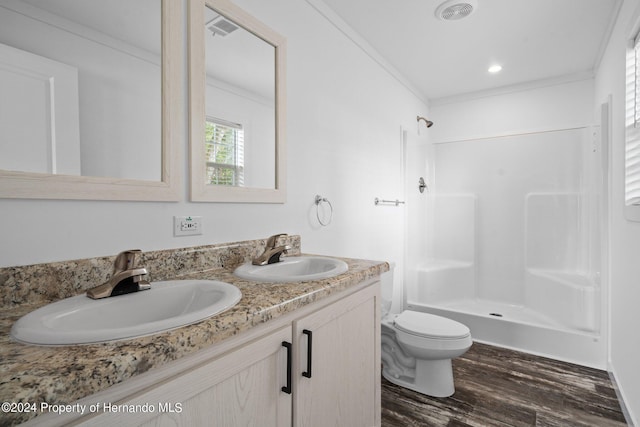 bathroom featuring crown molding, vanity, wood-type flooring, and toilet