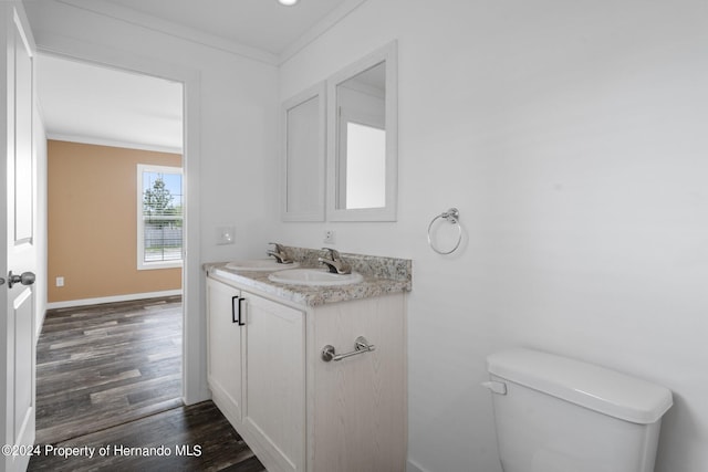 bathroom with hardwood / wood-style floors, vanity, toilet, and ornamental molding