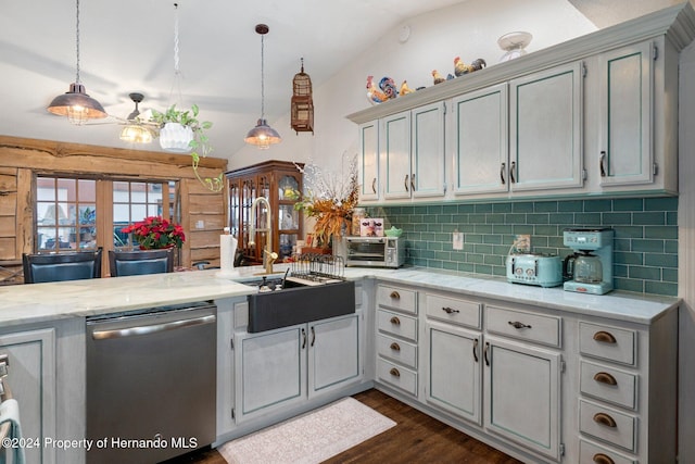 kitchen with stainless steel dishwasher, vaulted ceiling, dark wood-type flooring, sink, and decorative light fixtures