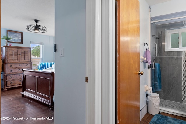 bathroom featuring hardwood / wood-style floors, vanity, and a tile shower