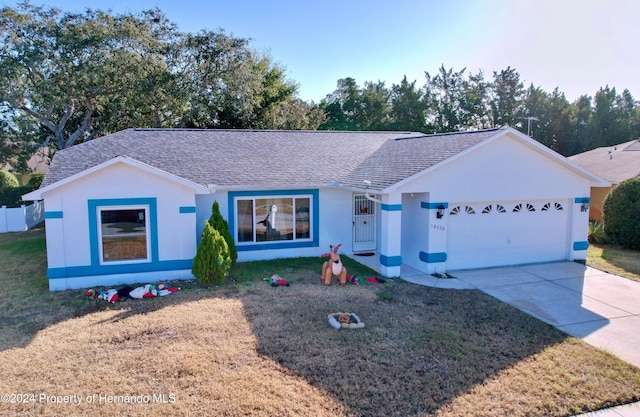 ranch-style home featuring a garage and a front lawn