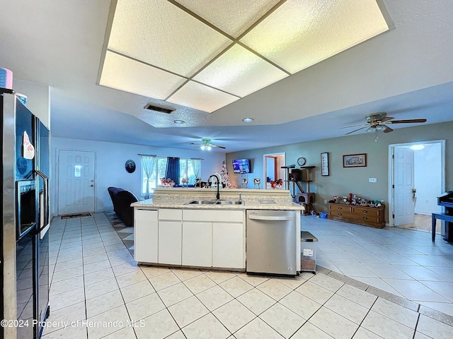 kitchen with dishwasher, black fridge, sink, light tile patterned floors, and white cabinetry