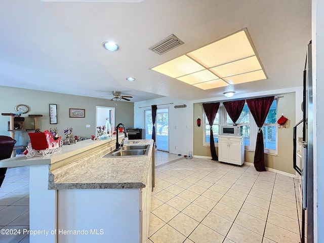 kitchen featuring ceiling fan, light tile patterned flooring, sink, and a wealth of natural light