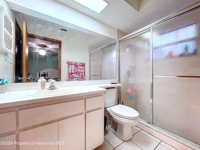 bathroom featuring tile patterned flooring, vanity, toilet, and walk in shower