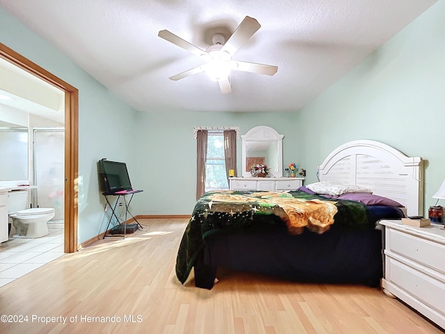 bedroom with connected bathroom, ceiling fan, light hardwood / wood-style floors, and a textured ceiling