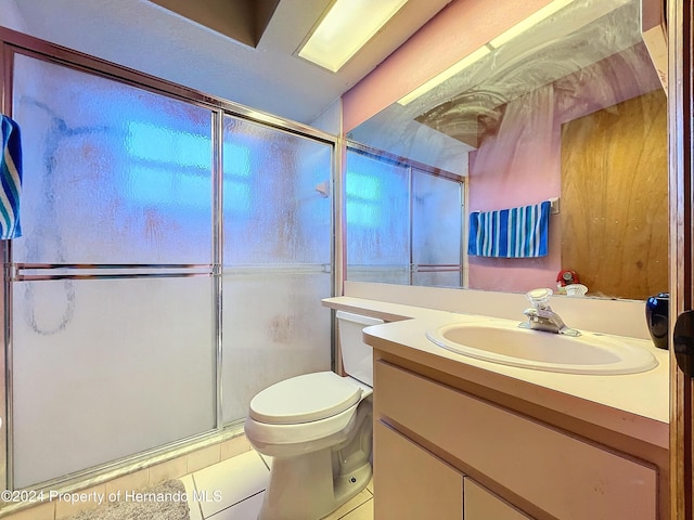 bathroom with toilet, tile patterned flooring, vanity, and walk in shower