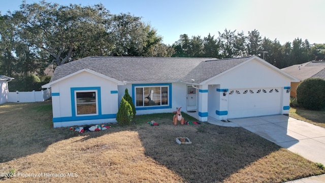 ranch-style home with a garage and a front lawn