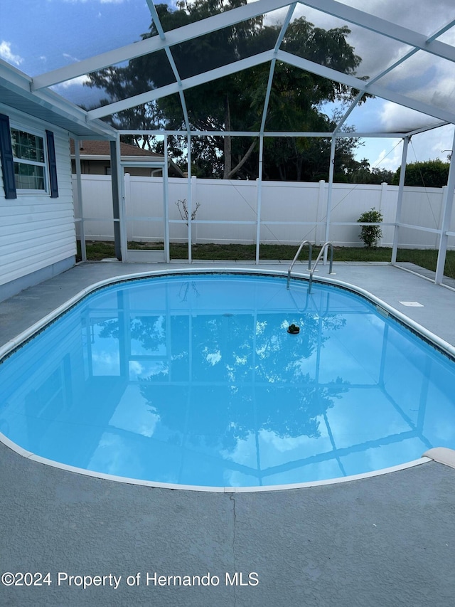 view of swimming pool with a lanai and a patio area