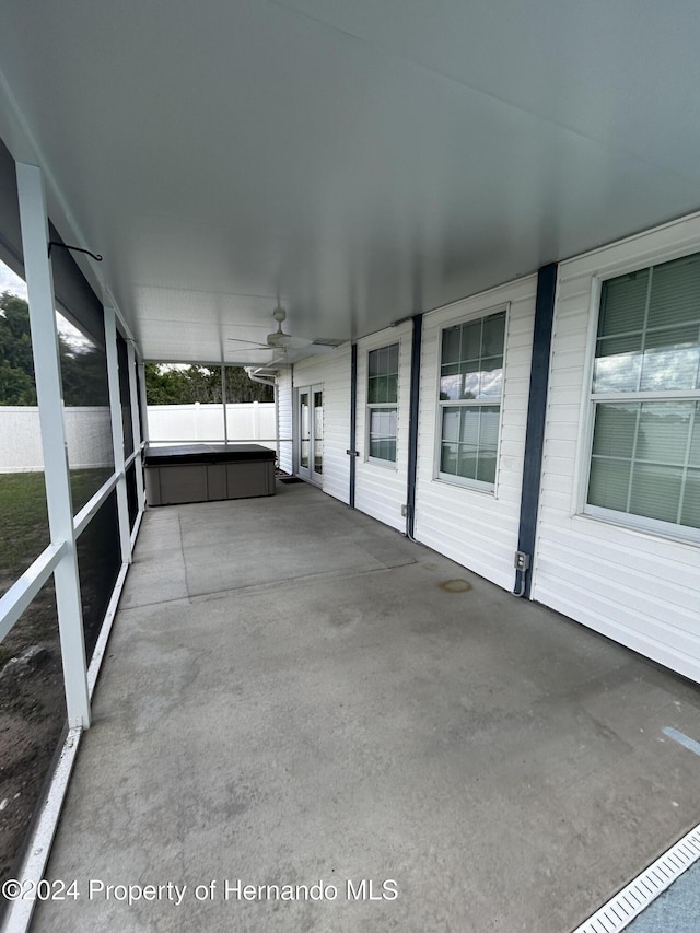 unfurnished sunroom with ceiling fan