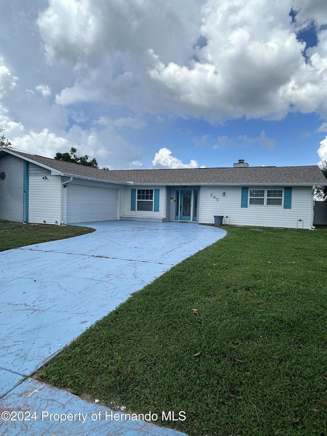 ranch-style house with a garage and a front lawn