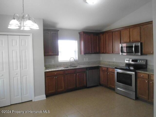 kitchen featuring hanging light fixtures, sink, vaulted ceiling, appliances with stainless steel finishes, and a notable chandelier