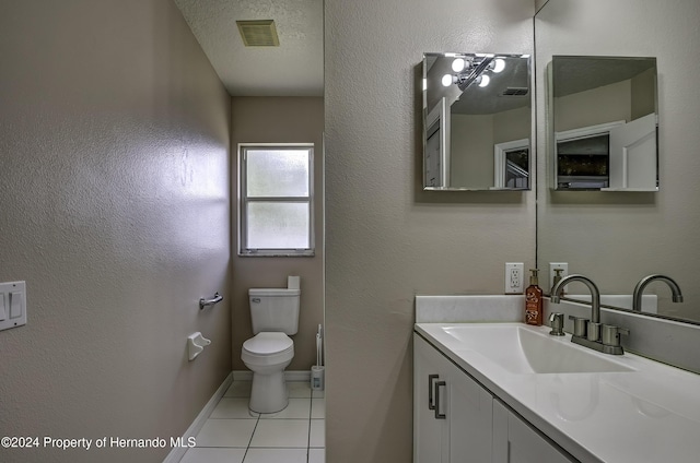 bathroom featuring tile patterned floors, vanity, a textured ceiling, and toilet