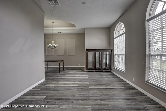 entryway with dark wood-type flooring, a healthy amount of sunlight, and an inviting chandelier