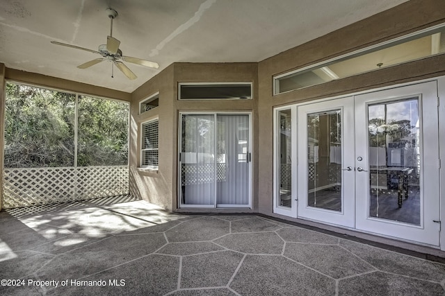 unfurnished sunroom with a ceiling fan and french doors