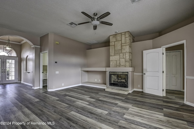 unfurnished living room featuring a textured ceiling, ceiling fan, dark wood-type flooring, and french doors