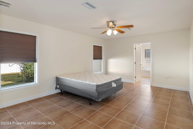 unfurnished bedroom with connected bathroom, ceiling fan, and tile patterned flooring