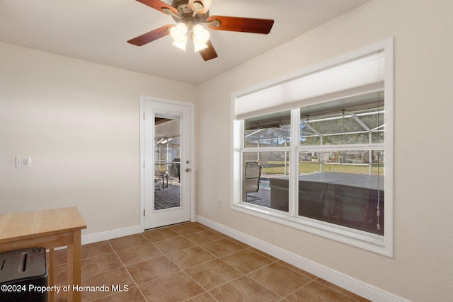 doorway featuring ceiling fan and light tile patterned flooring