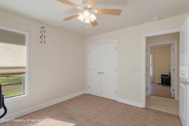 unfurnished bedroom with ceiling fan, a closet, and light hardwood / wood-style floors