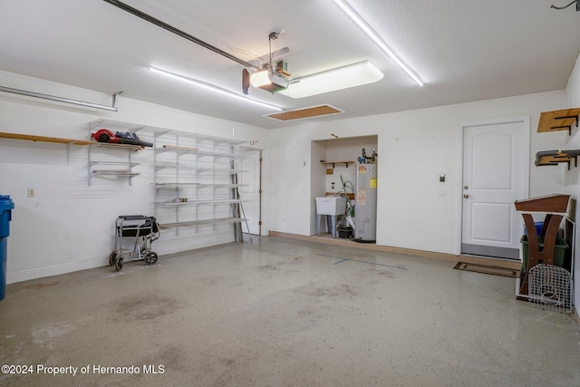 garage featuring electric water heater, sink, and a garage door opener