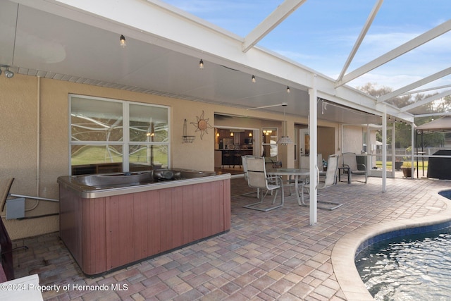 view of patio / terrace featuring glass enclosure and a pool